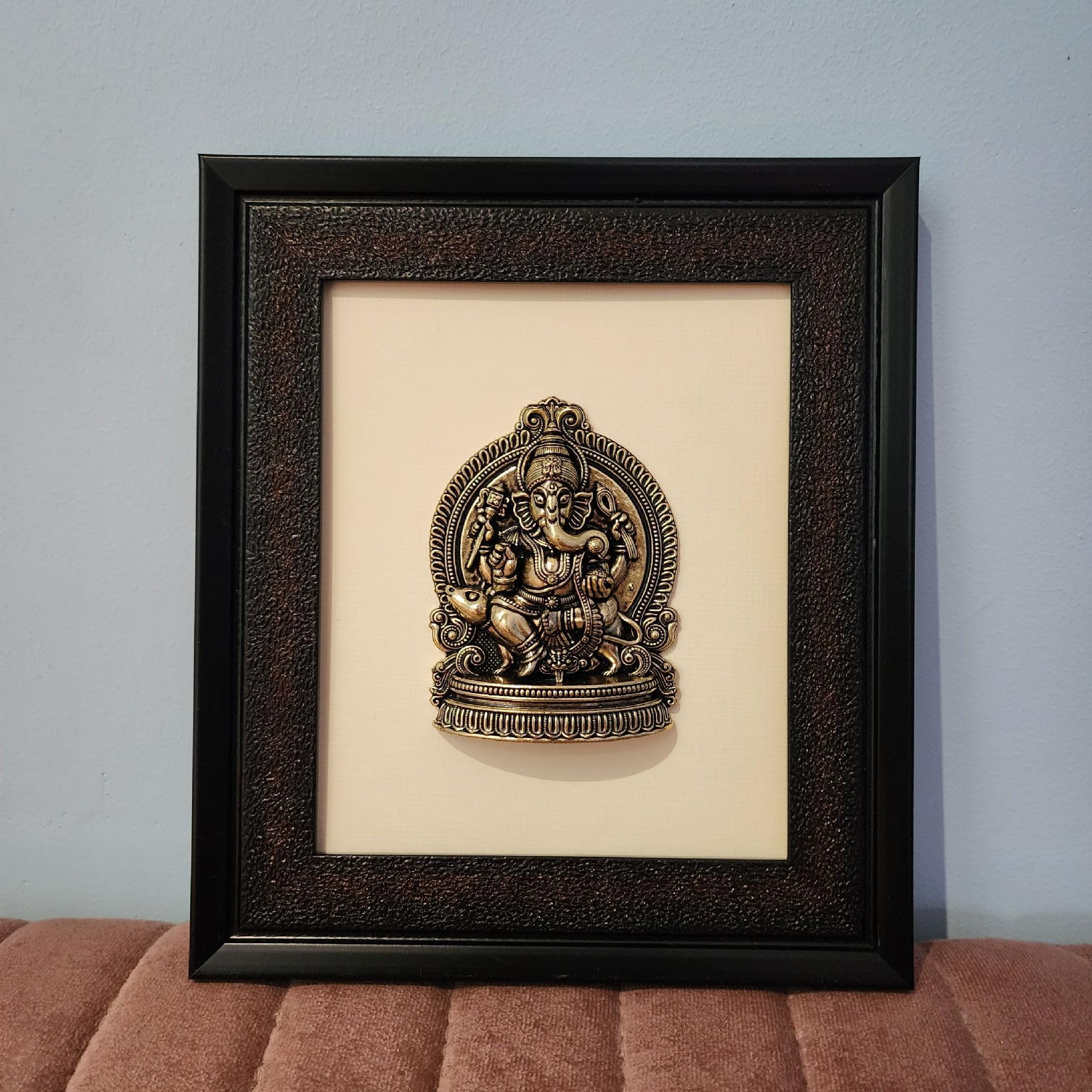 Framed decorative wall art with a religious icon on a beige background