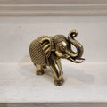 Gold elephant figurine on a light surface