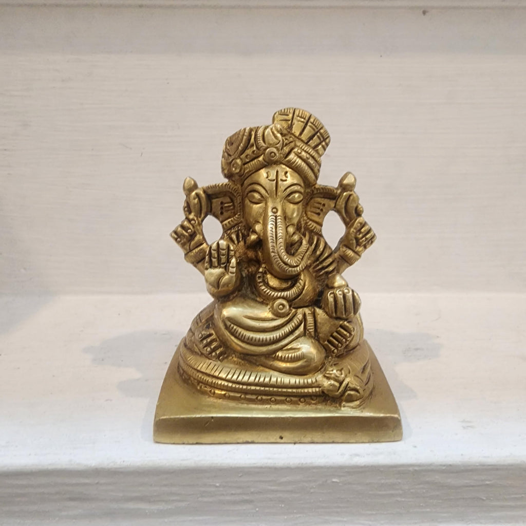 Brass statue of a deity on a white marble surface