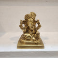 Brass statue of a deity on a white marble surface