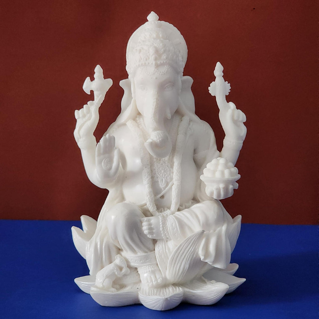 White marble statue of a seated figure on a blue platform with a red background
