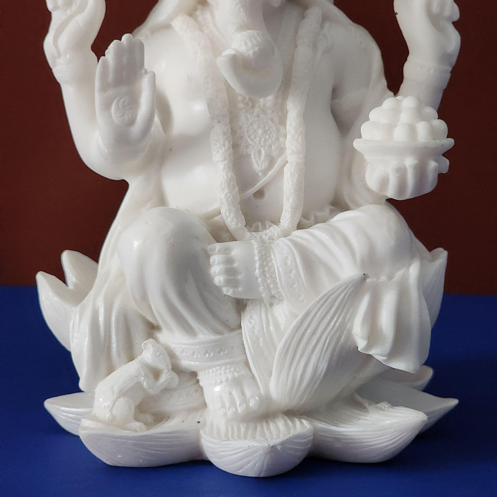 White marble statue of a seated figure on a blue and brown gradient background