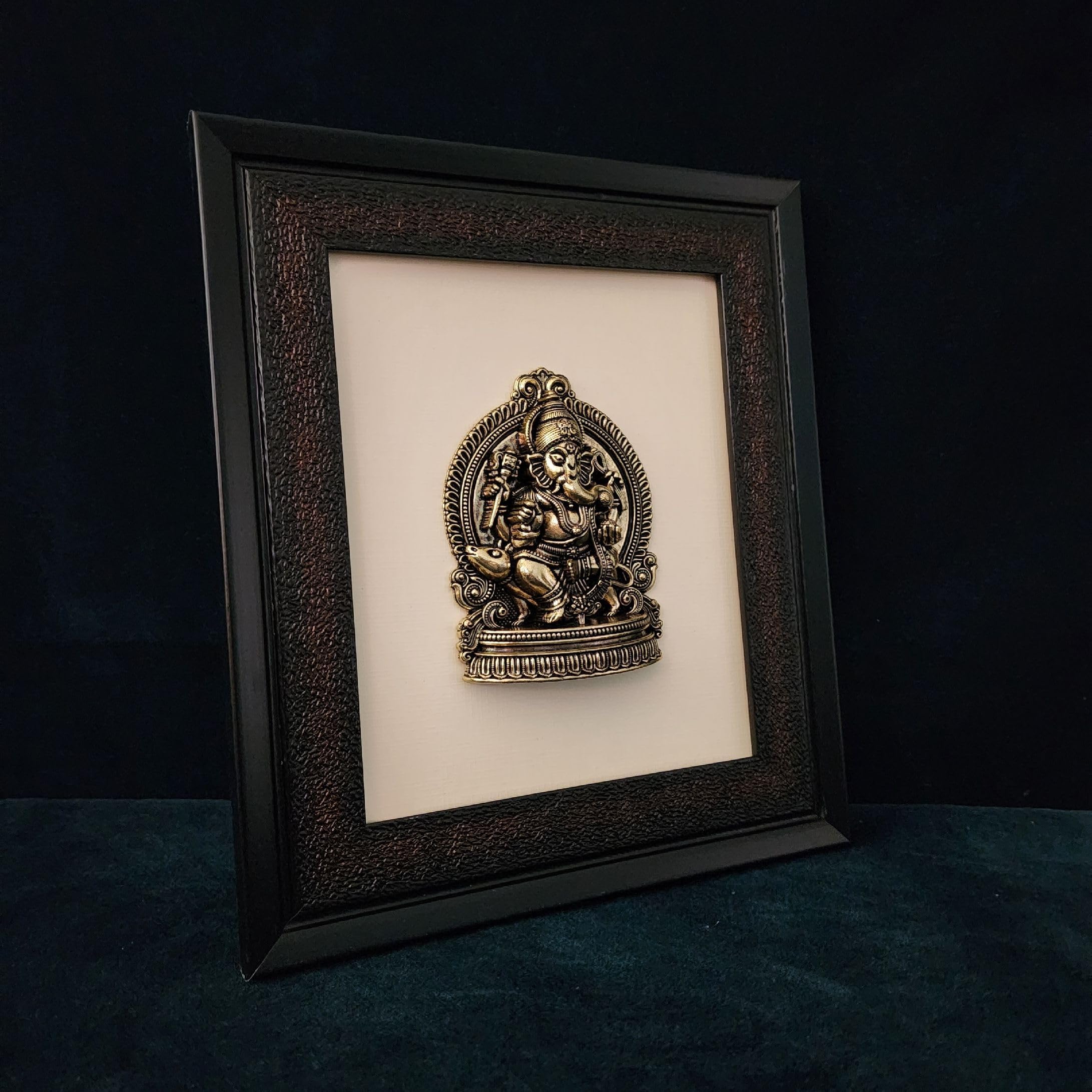 Framed decorative wall art with intricate design on a dark background
