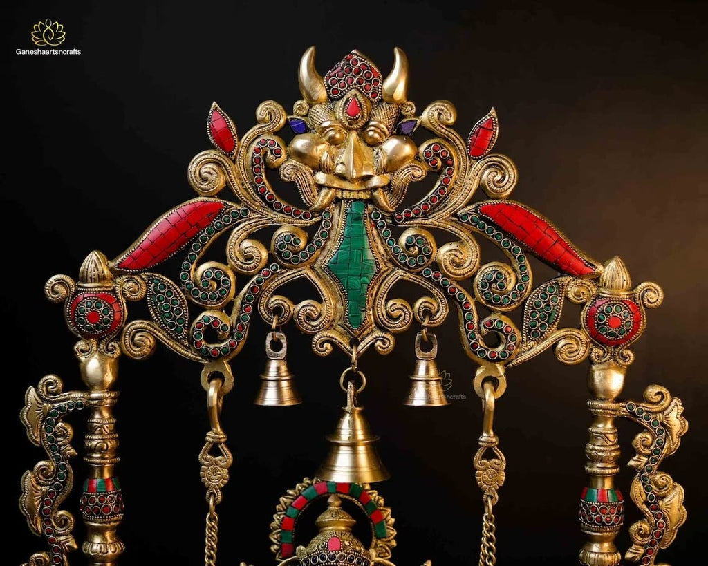 Decorative Ganesh statue on a swing with intricate gold and colored stone detailing.