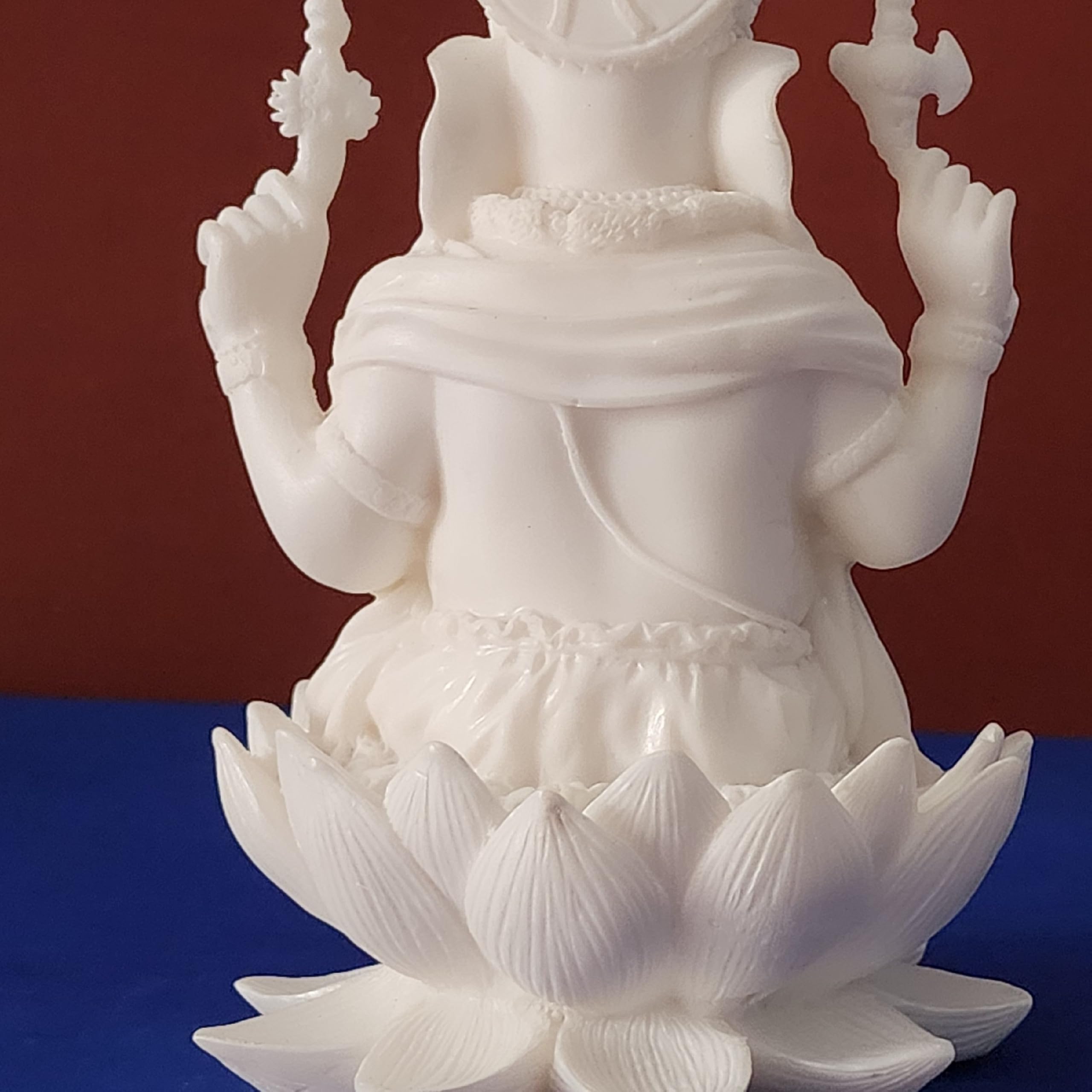 White statue of a deity on a blue and red background
